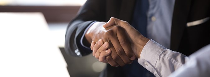 Close up african businessman shaking hands with client