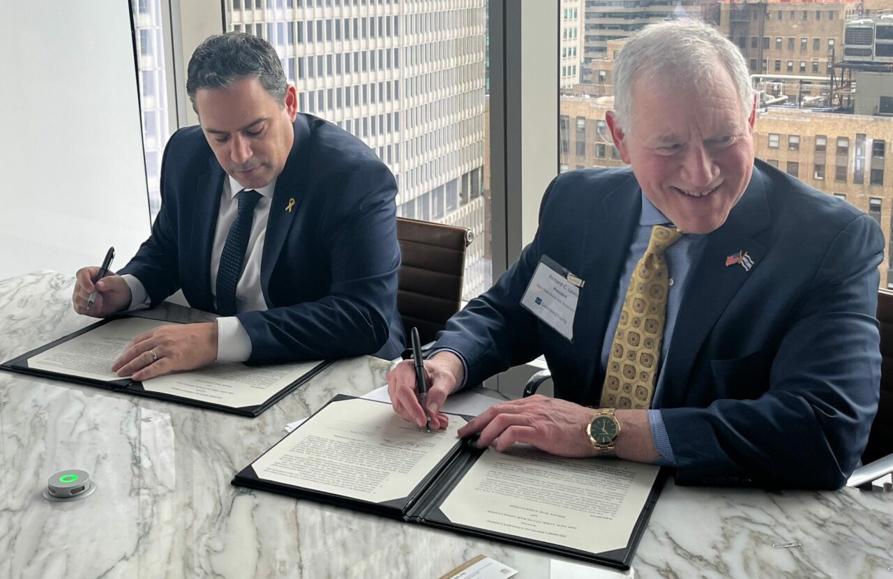 Amit Becher, president of the Israel Bar Association, and Richard Lewis, president of the New York State Bar Association, sign a Memorandum of Understanding.