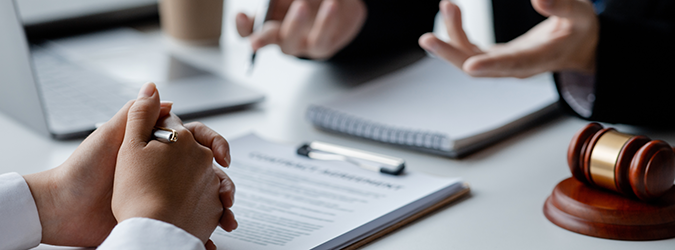 Picture of two sets of hands on top of a pad of paper, as if in a meeting.