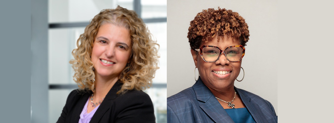 Two women in business attire smiling at the camera; one has curly blonde hair and a black blazer, the other has short curly hair, glasses, and a blue blazer, standing against neutral backgrounds.