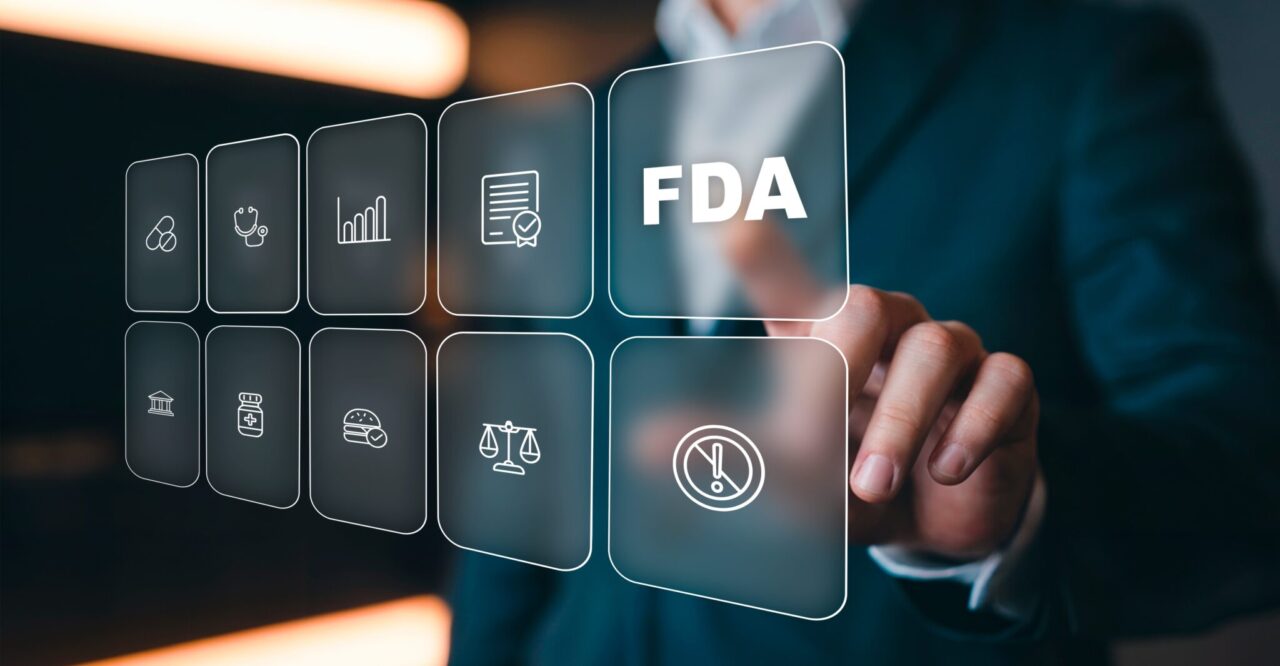 A person in a suit touches a transparent digital screen with various icons, including one labeled FDA in bold letters, representing healthcare and regulatory concepts.