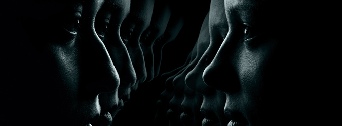 A dark, artistic image showing multiple overlapping profiles of human faces in shadow, facing each other and fading into the darkness on both sides of the image.