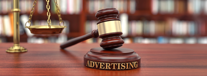 A judges gavel rests on a block labeled ADVERTISING, with scales of justice in the background and bookshelves blurred behind.